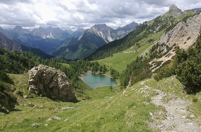 veduta dall'alto di un laghetto alpino incastonato tra le montagne carniche