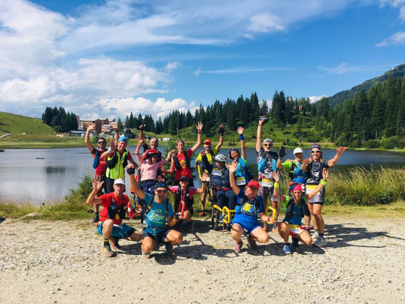 un gruppo di atleti di Carnica Ultra Trail davanti ad un laghetto alpino